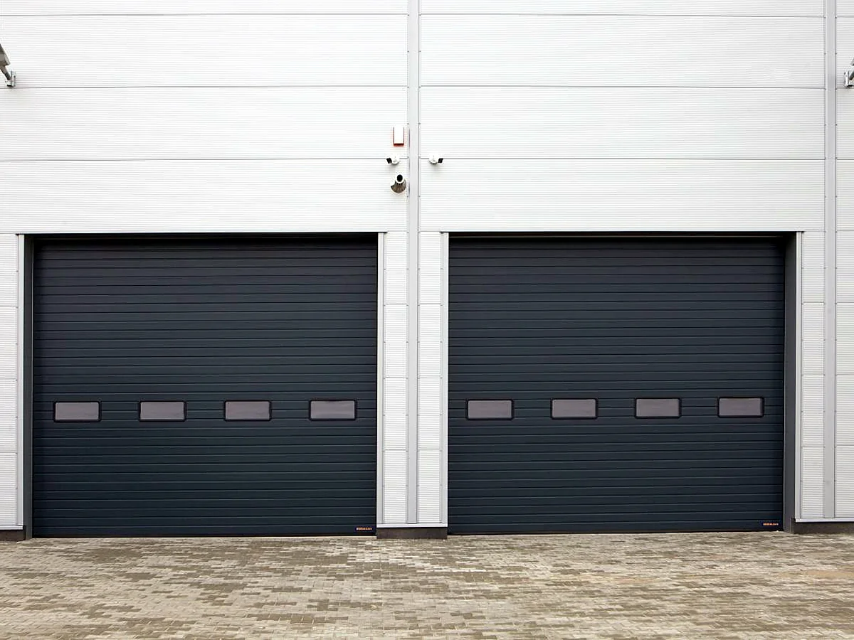 Two dark commercial rolling doors on an industrial building