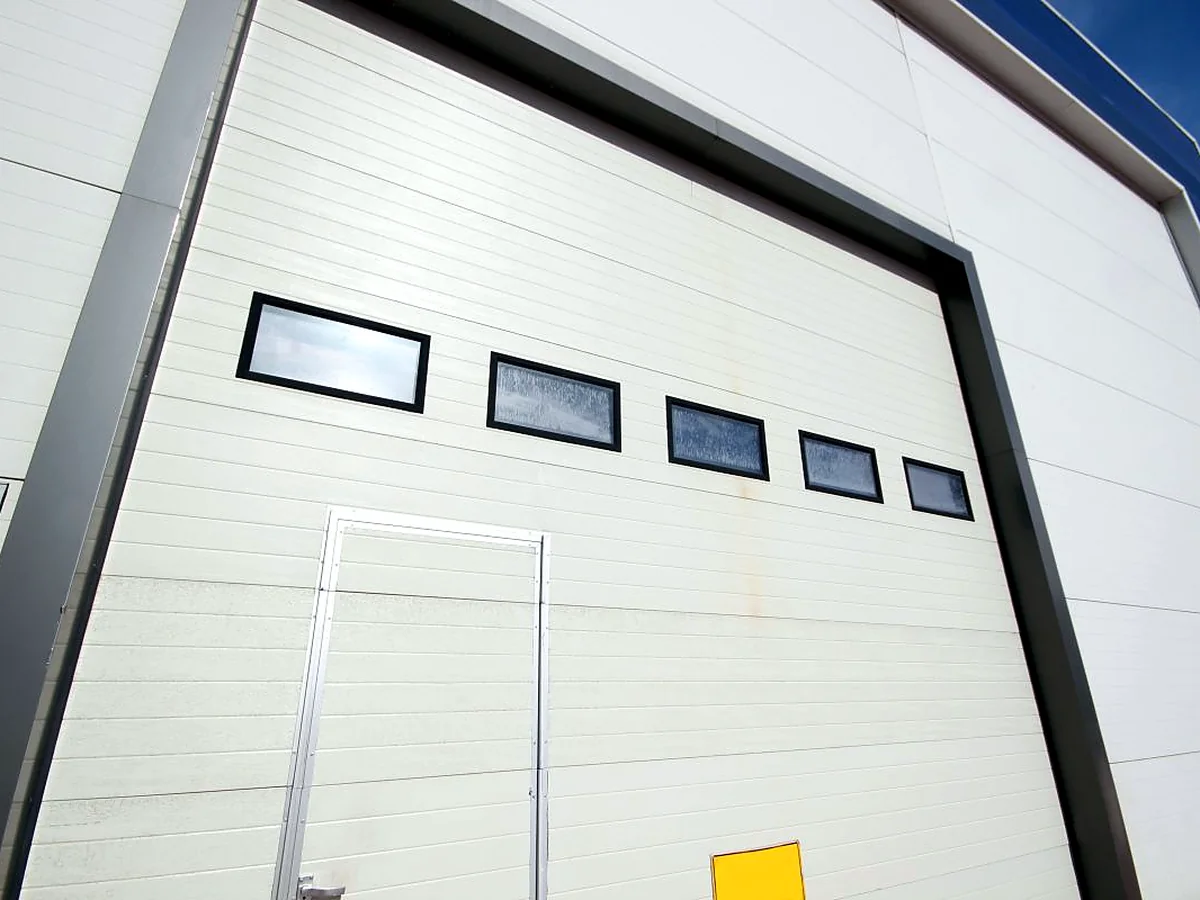 White commercial sectional overhead door with vision panels