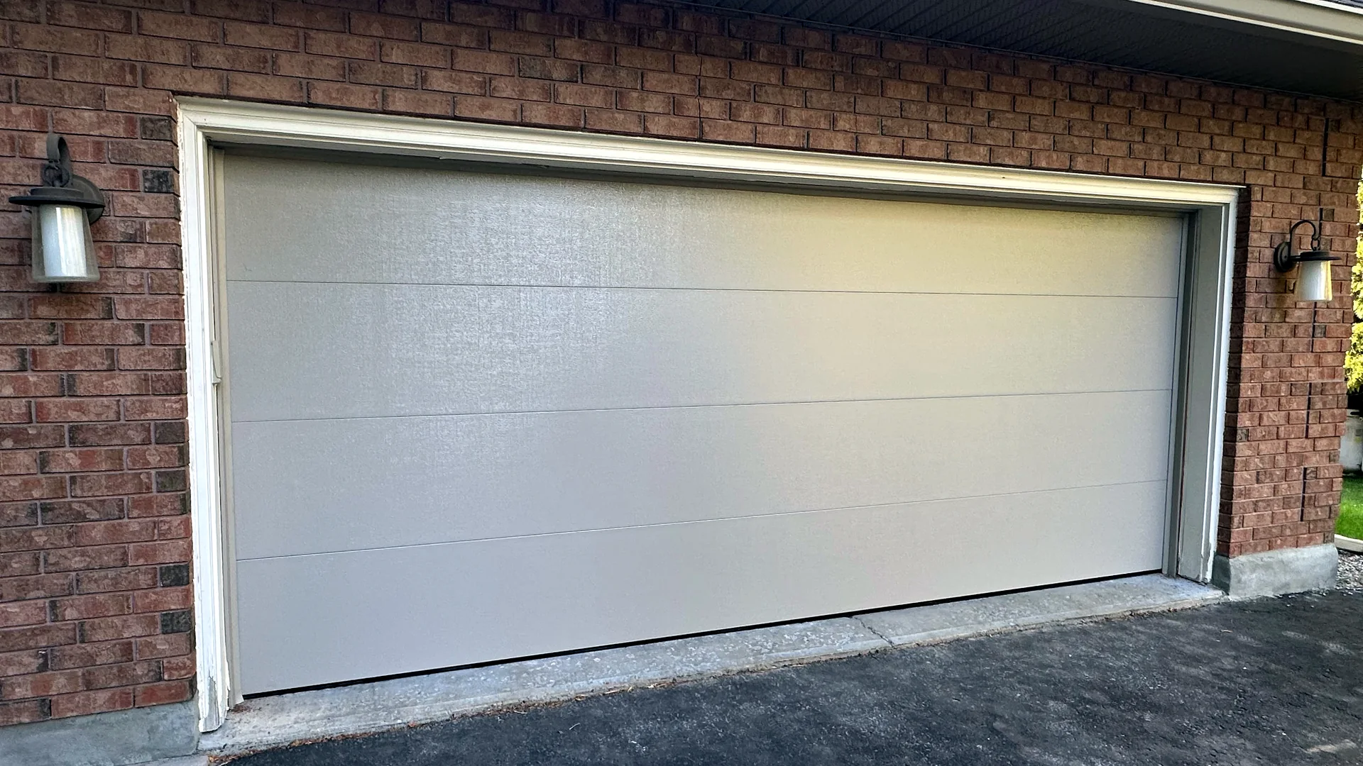 Wide white contemporary garage door ready for seasonal maintenance
