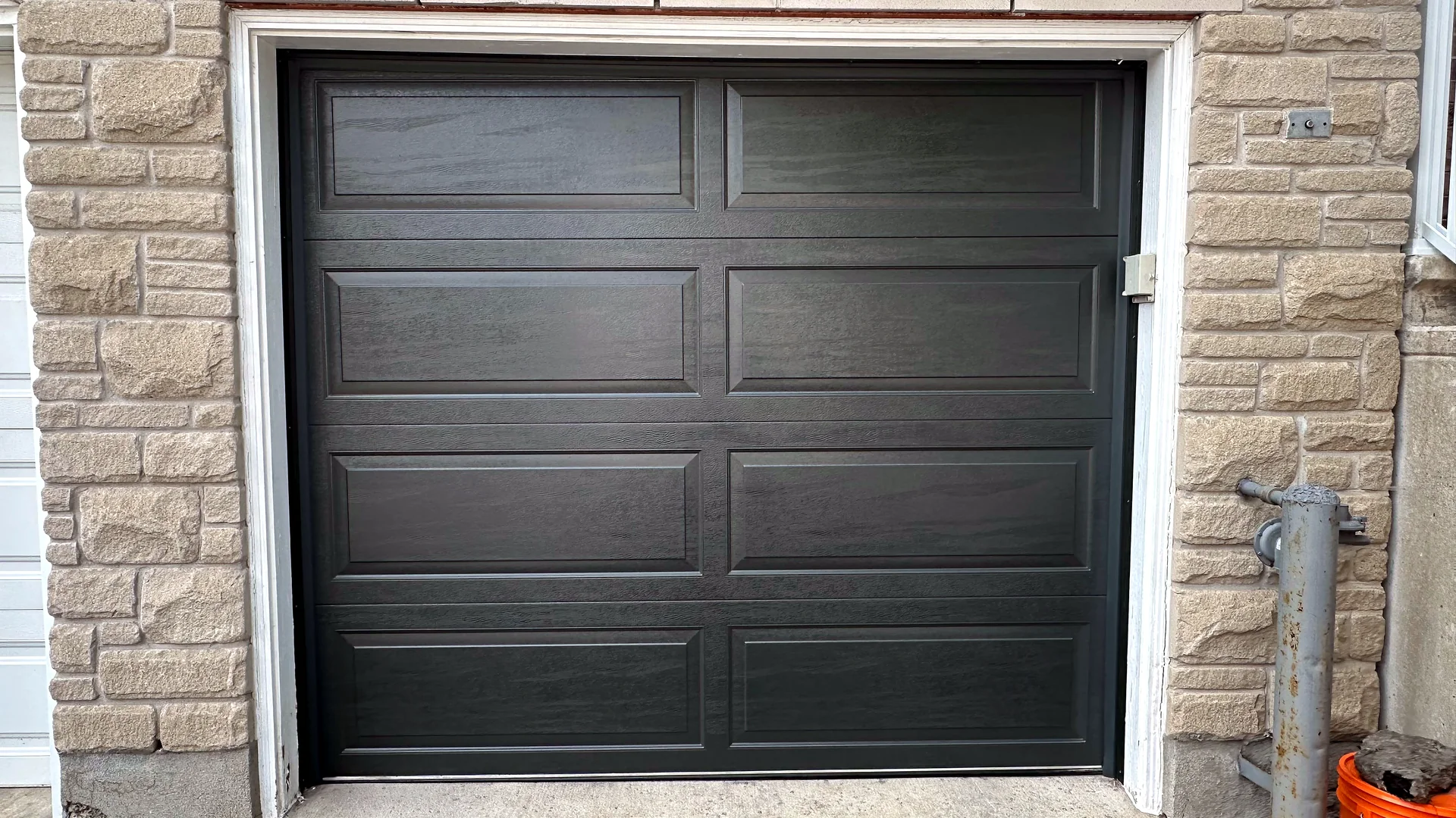 Black sectional garage door on a Calgary home for the spring replacement service page