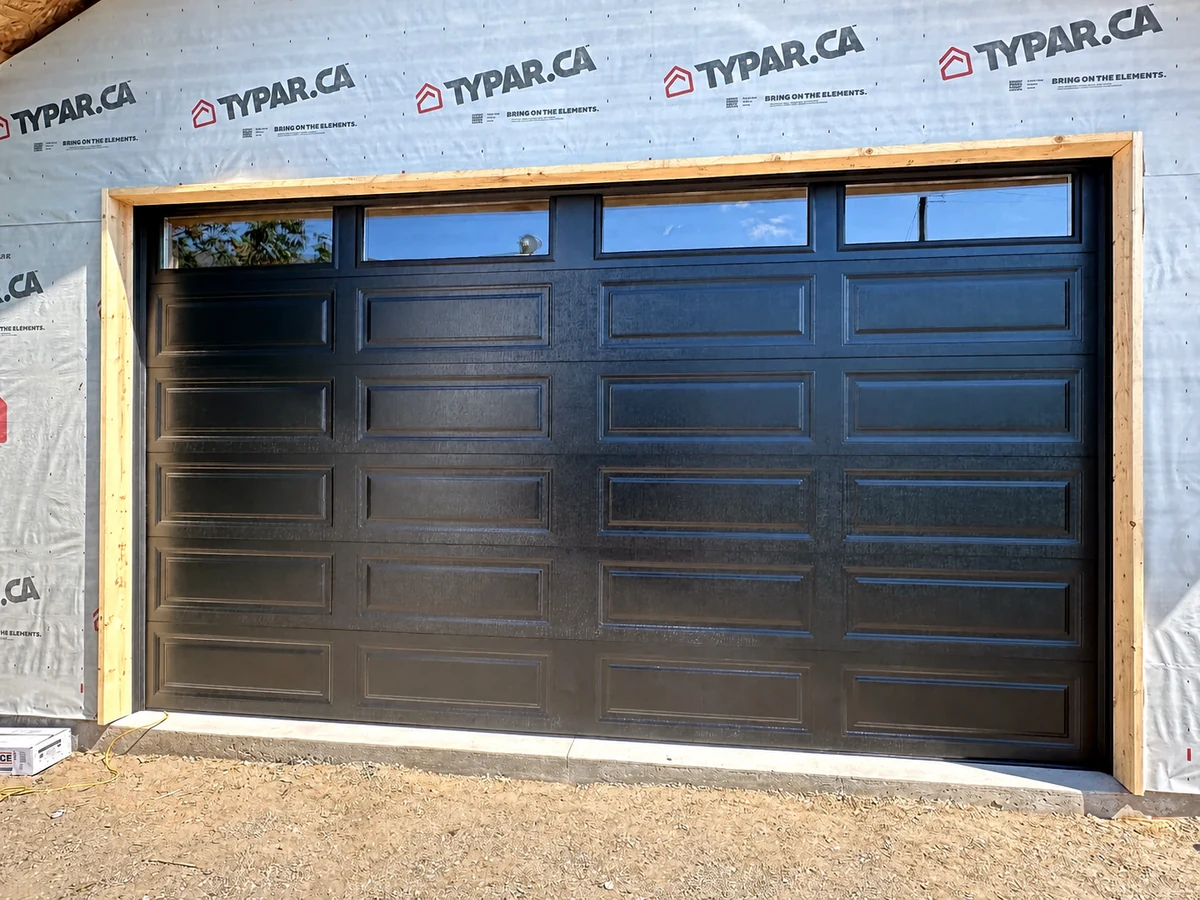 Black raised-panel garage door at a Calgary new-construction project