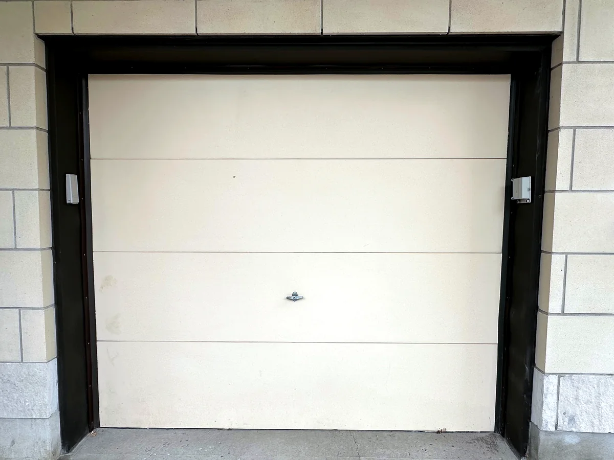 Cream sectional garage door in a finished opening
