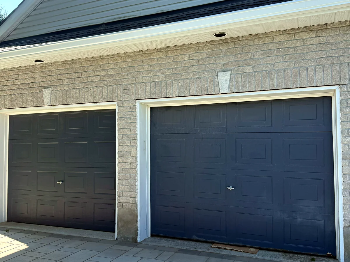 Two black sectional garage doors on a residential garage