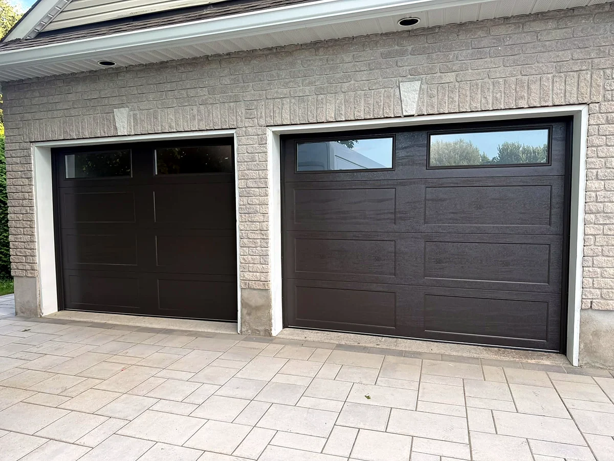 Two matching brown garage doors with windows installed on separate residential openings