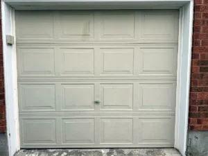 Weathered white raised-panel garage door ready for assessment