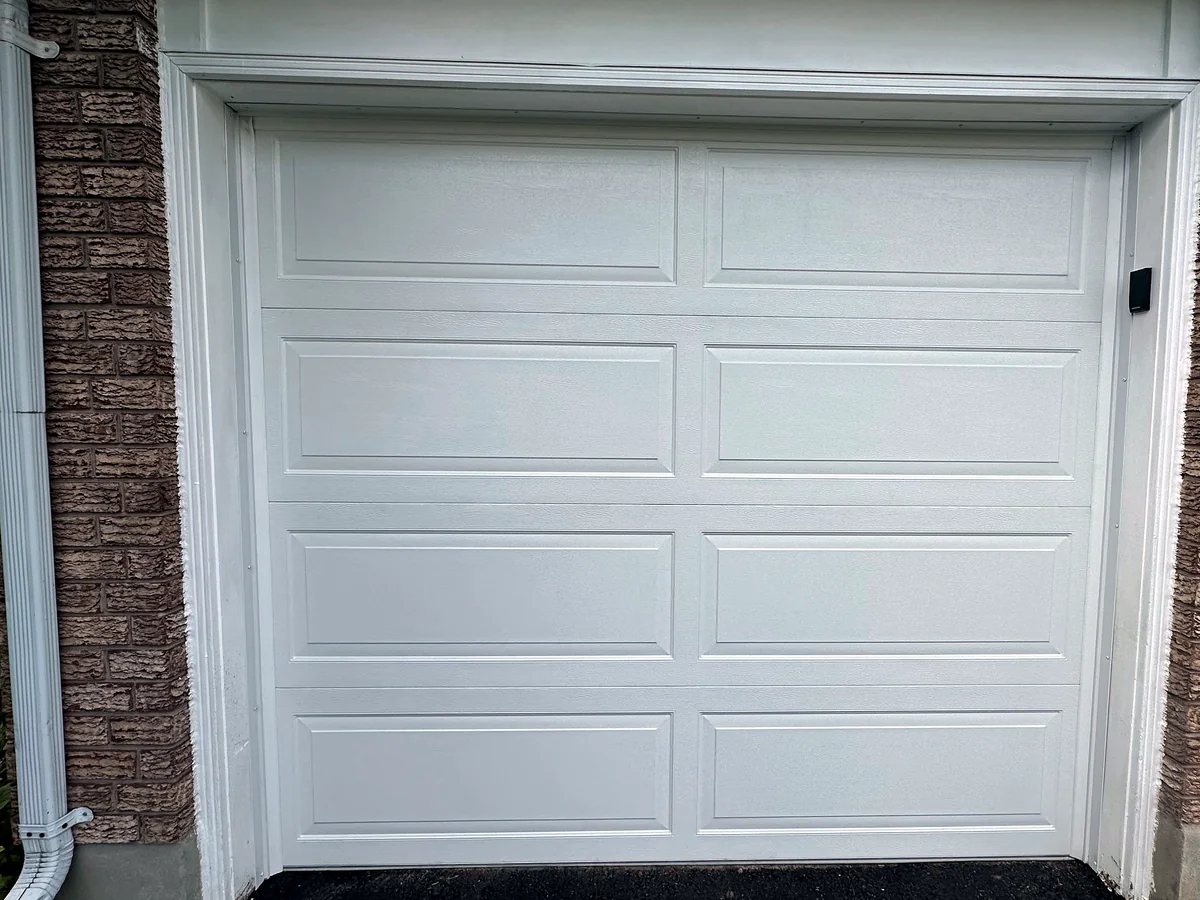 White carriage-style garage door with rectangular panels