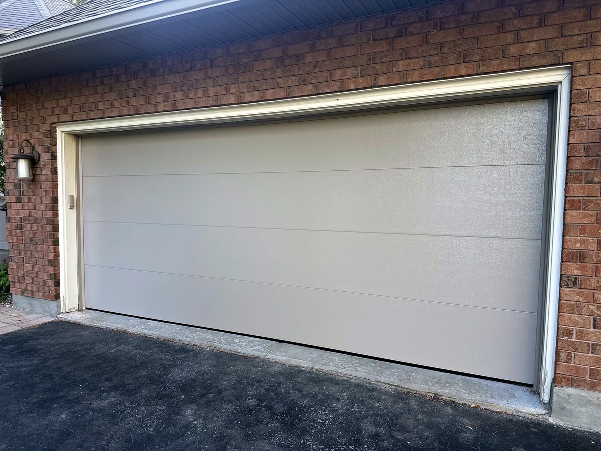 Wide white contemporary garage door with clean horizontal sections