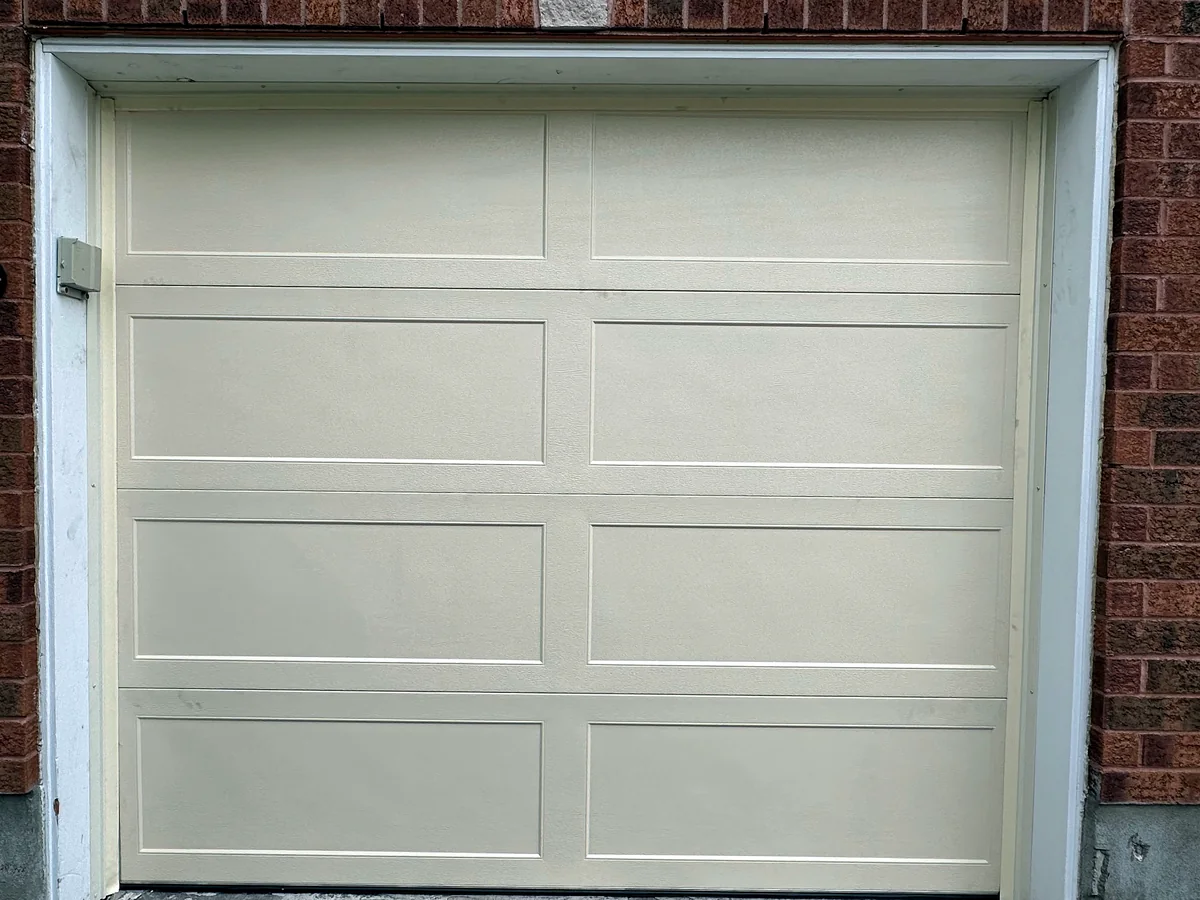 White sectional garage door in a brick residential opening