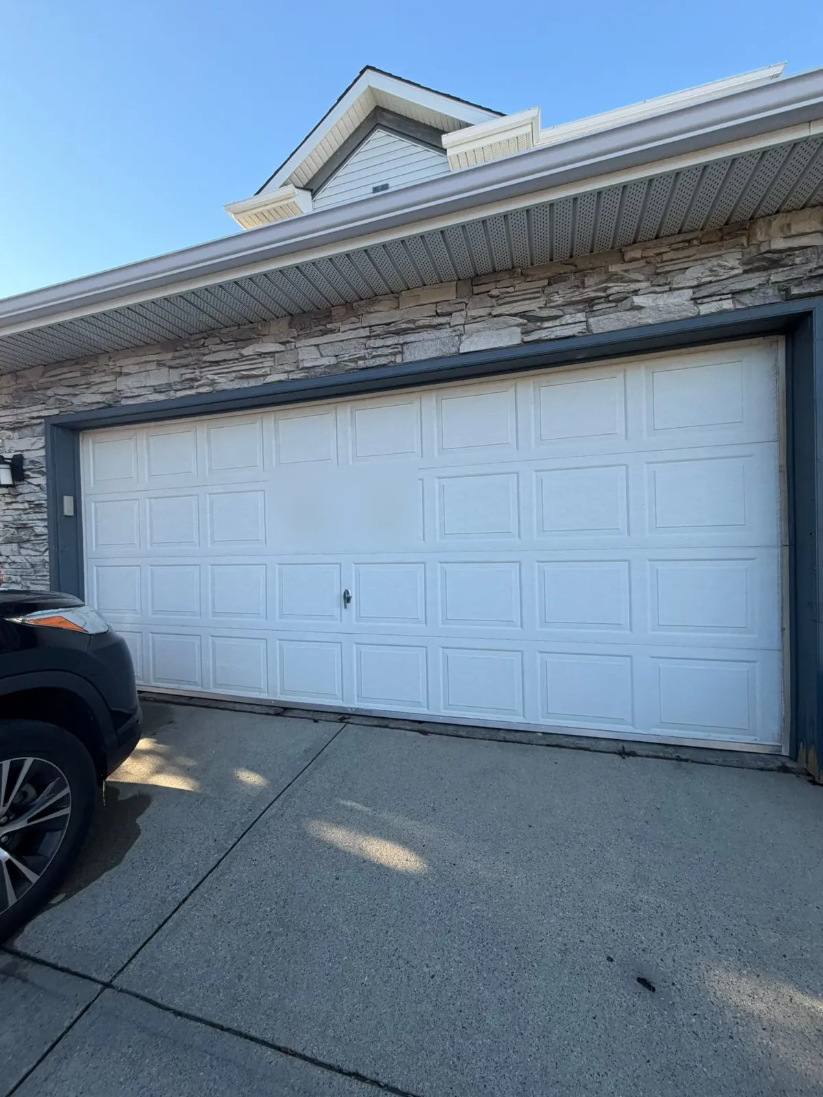 Before: older white short-panel garage door on a Calgary home before the Raised Ranch replacement