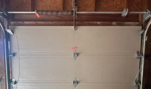 New torsion spring with a red tag installed above a Calgary garage door