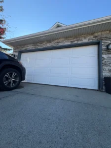 White Richards-Wilcox Raised Ranch R18 insulated garage door installed on a Calgary home with stone trim