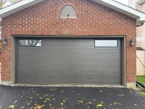 Slate grey Richards-Wilcox flush garage door with two top windows on a Calgary brick garage